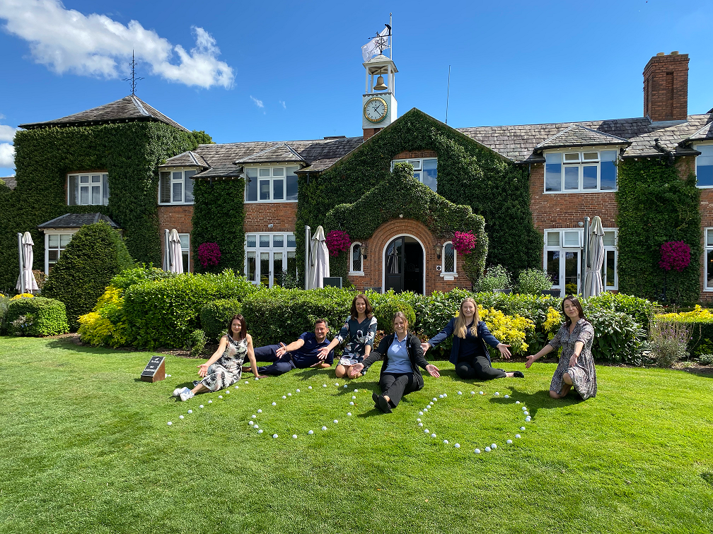 100 outlined in golf balls with staff from Destination Coventry and The Belfry